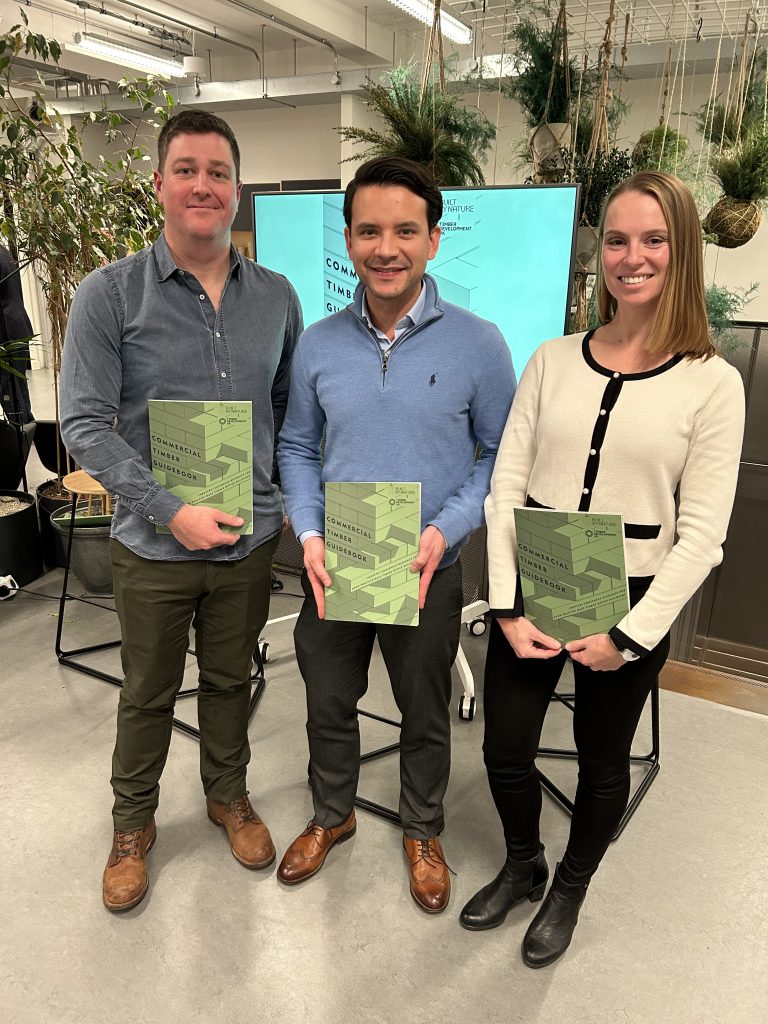 OFR Colleagues Sam Liptrott, Luis Gonzalez Avila and Carmen Gorska, all stood together holding a copy o the Commercial Timber Guidebook, to which they all contributed,